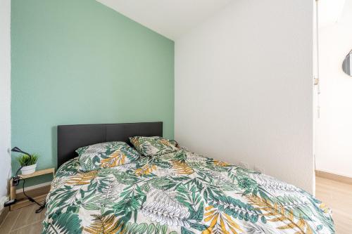 une chambre avec un lit avec une couette colorée dans l'établissement Le Studio des Dunes - A 50m de la plage, à Soulac-sur-Mer