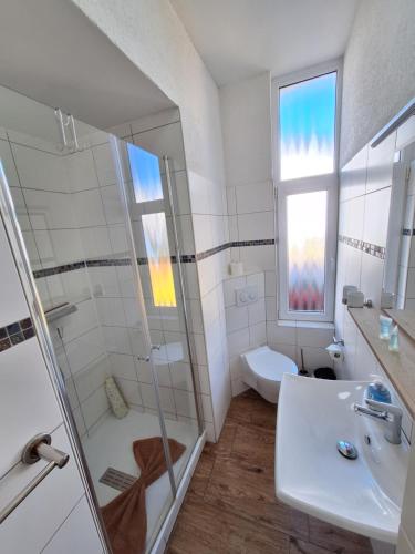 a bathroom with a shower and a sink and a toilet at Pension Kapitän Schmuck in Borkum