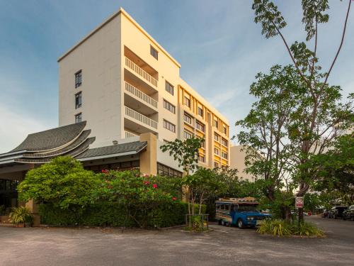 a building with a blue truck parked in front of it at Recenta Phuket Suanluang in Phuket Town