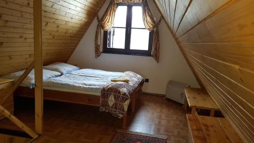 a small bed in a room with a window at Horský Dom Tále in Bystrá
