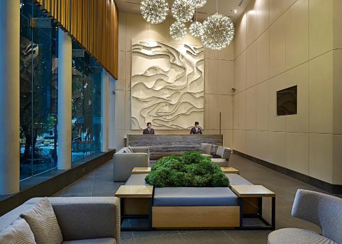 a lobby with chairs and a table with plants at ANSA Hotel Kuala Lumpur in Kuala Lumpur