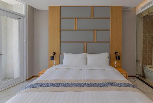 a bedroom with a large bed and a window at Sun Moon Lake Apollo Resort Hotel in Yuchi