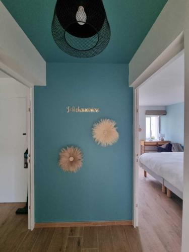 une chambre avec un mur bleu avec deux affiches dessus dans l'établissement La Chauvinière, à Montaigu-Vendée