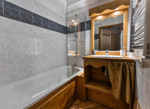 une salle de bain avec un lavabo, une baignoire et un miroir dans l'établissement Résidence Les Hauts De Preclaux - Appartement cosy au coeur des Orres 1800 MAE-9171, aux Orres