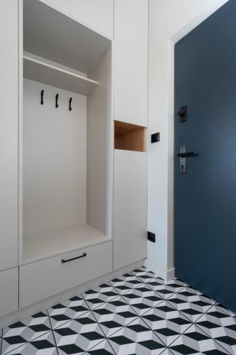 a kitchen with a blue door and a black and white floor at Apartamenty Rocha in Pabianice