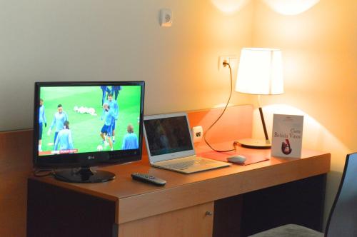escritorio con ordenador portátil y TV en FC Infantas de León en León