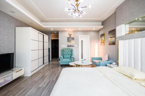 a bedroom with a large bed and blue chairs at Tech-X Jing'an Hotel in Shanghai