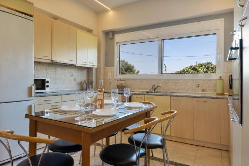 a kitchen with a table and chairs and a window at Artemida Beach House in Artemida