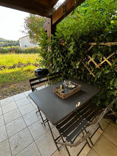 une table noire et des chaises sur une terrasse dans l'établissement Maison avec terrasse et parking, à 350 m de la plage, à Saint-Martin-dʼArdèche