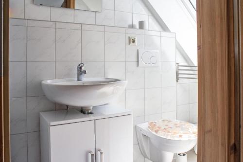 a white bathroom with a sink and a toilet at Ferienwohnung Ferienhäuser am Brocken, 80 qm, 3 Schlafzimmer in Ilsenburg