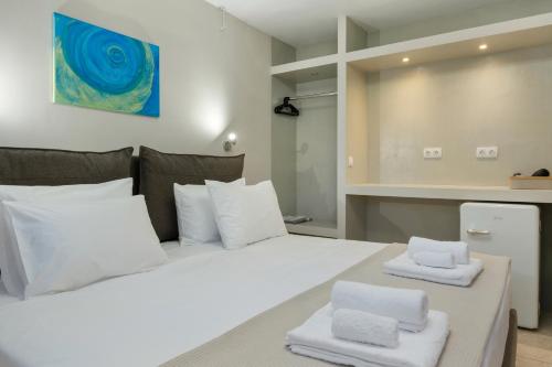 a bedroom with a white bed with towels on it at Artemida Beach House in Artemida