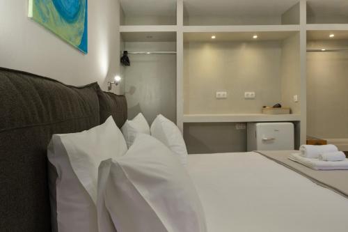 a bedroom with a bed with white sheets and pillows at Artemida Beach House in Artemida