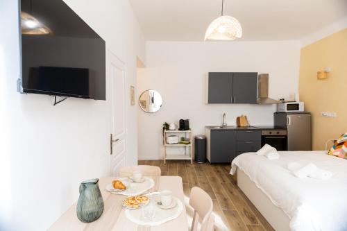 Cette chambre comprend un lit, une table et une cuisine. dans l'établissement Maison Sylvabelle - Confort d'exception - Quartier des Antiquaires -, à Marseille