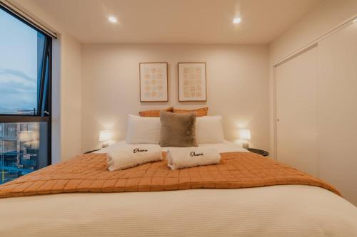 Un dormitorio con una cama grande con dos almohadas. en Central 1BR Apt - Balcony Kitchen & Bath, en Christchurch
