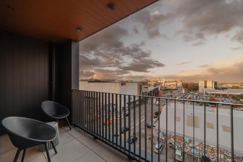 Un balcón con sillas y vista a una ciudad. en Central 1BR Apt - Balcony Kitchen & Bath, en Christchurch