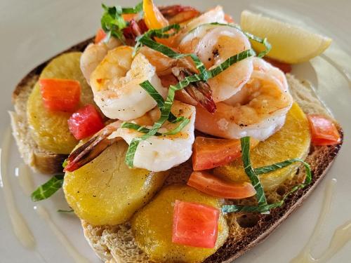 a sandwich with shrimp and fruit on a plate at Wai Resort - Raja Ampat in Pulau Birie