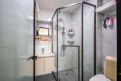 a bathroom with a shower and a sink at Tech-X Jing'an Hotel in Shanghai