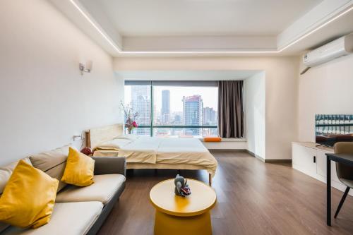 a hotel room with a bed and a couch at Tech-X Jing'an Hotel in Shanghai