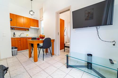 a living room with a table and a tv on a wall at Beachfront Cozy Apartments in Ammoudara in Amoudara Herakliou