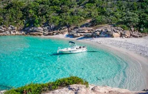 a boat sitting in the water on a beach at Awesome Home In Oletta in Oletta