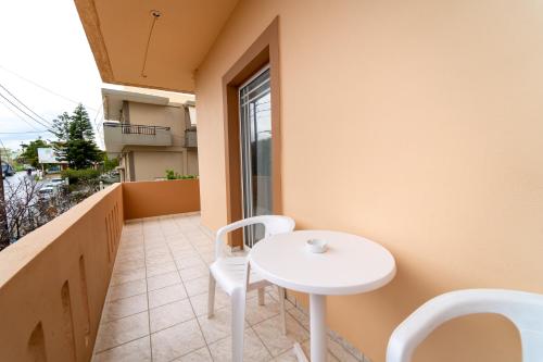 a small white table and chairs on a balcony at Beachfront Cozy Apartments in Ammoudara in Amoudara Herakliou