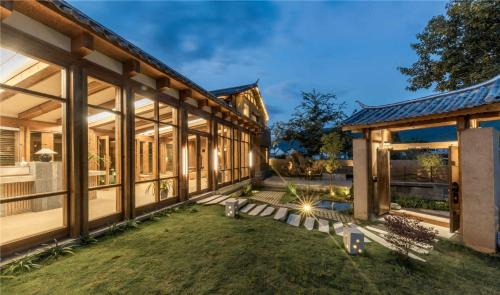 an exterior view of a house with a yard at Shaxi Ancient Town Shiran Mountain Homestay in Jianchuan