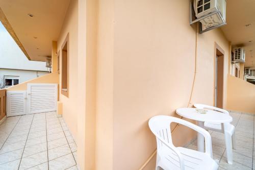 a small balcony with a table and white chairs at Beachfront Cozy Apartments in Ammoudara in Amoudara Herakliou