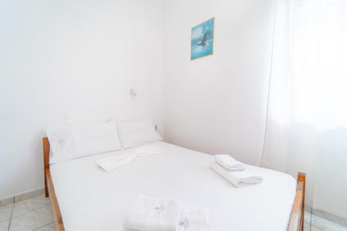a small bedroom with a white bed and a mirror at Beachfront Cozy Apartments in Ammoudara in Amoudara Herakliou