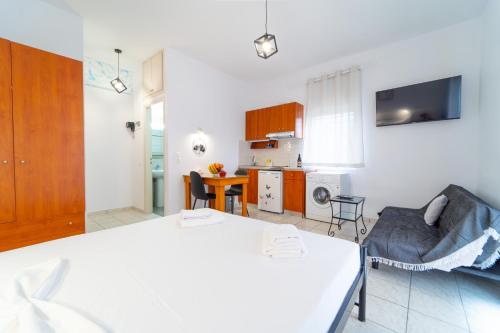 a room with a bed and a living room with a kitchen at Beachfront Cozy Apartments in Ammoudara in Amoudara Herakliou