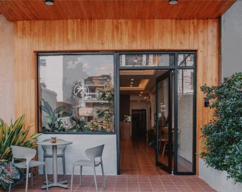una puerta de cristal que da a un patio con mesa y sillas en Muulao Hostel, en Vientiane