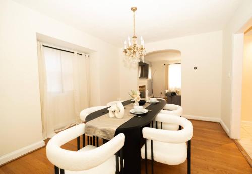 a dining room with a black table and white chairs at Sunnyside Nest in Washington, D.C.