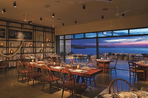 a restaurant with tables and chairs and a view of the ocean at Breathless Cabo San Lucas - Adults Only in Cabo San Lucas