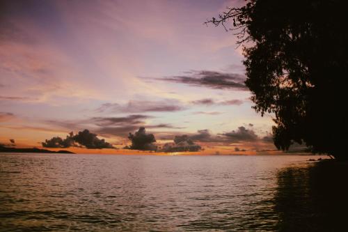 a sunset over a large body of water at Wai Resort - Raja Ampat in Pulau Birie
