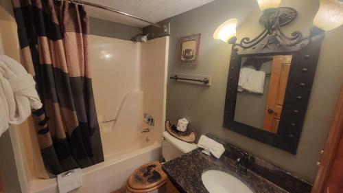 a bathroom with a sink and a mirror and a tub at Mountain View Retreats in Gatlinburg