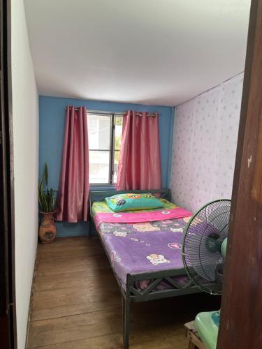 a small room with a bed and a fan at Ayutthaya Par Plearn Homestay อยุธยา พาเพลินold BJ Guesthouse in Phra Nakhon Si Ayutthaya