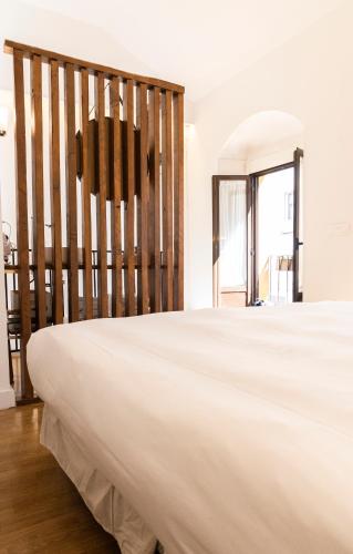 a bedroom with a large white bed and a window at El Rincón de Pilar in Córdoba