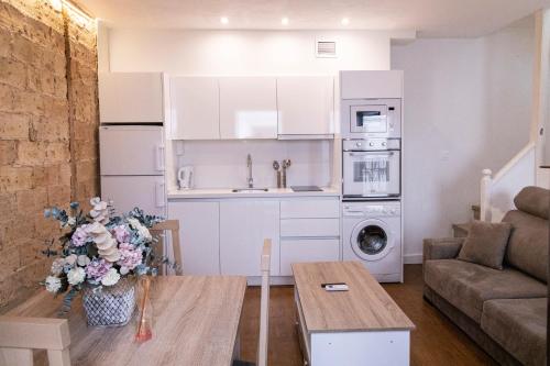 ein Wohnzimmer mit Tisch und Küche in der Unterkunft El Rincón de Pilar in Córdoba