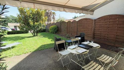 une table et des chaises dans une arrière-cour avec une clôture dans l'établissement Gîte 