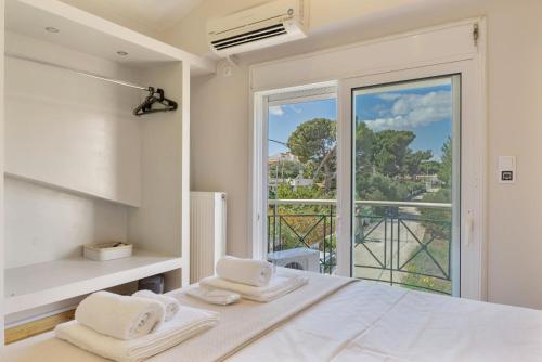 a bedroom with a bed and a large window at Artemida Beach House in Artemida