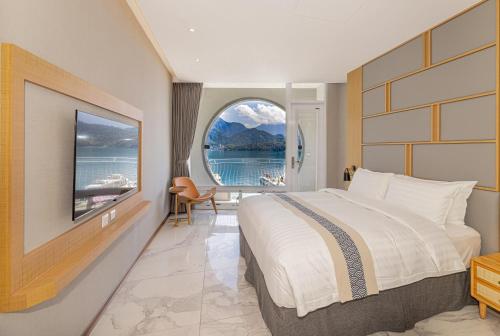 a hotel room with a large bed and a window at Sun Moon Lake Apollo Resort Hotel in Yuchi