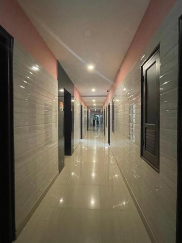 a hallway of a building with wooden walls and white floors at Nexstay Moments Inn in Trichūr