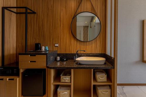 a bathroom with a sink and a mirror at Sun Moon Lake Apollo Resort Hotel in Yuchi
