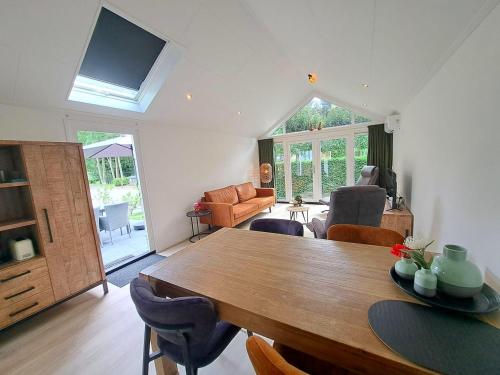 a living room with a wooden table and chairs at Moderne Tiny Chalet, 15min van Zeeuwse Kust VP072 in Heinkensand