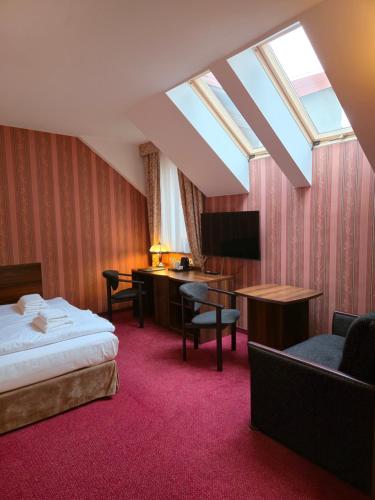 a hotel room with a bed and a desk at Hotel Dworski Galaktyczny Park in Szczecin