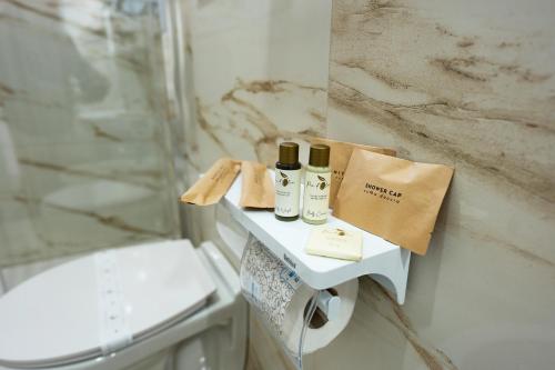a bathroom with a shelf with three bottles on it at Colè House in Bitetto