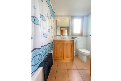 a bathroom with a tub and a sink and a toilet at Villa Mar in Cala en Bosc