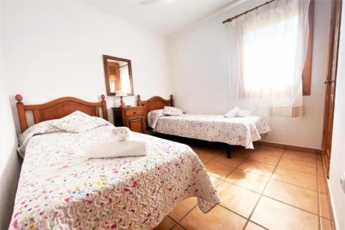 a bedroom with two beds and a window at Villa Mar in Cala en Bosc