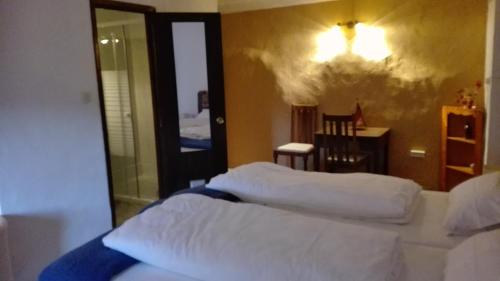 a bedroom with a bed with white sheets and a mirror at L'Almàssera Casa Rural & Restaurant in Margarida