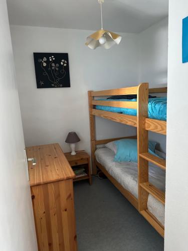 une chambre avec deux lits superposés et un bureau dans l'établissement Carnac plage T2 avec terrasse Pour 4 personnes, à Carnac