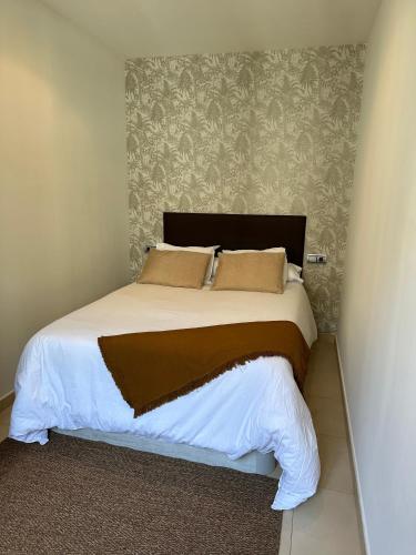 a bedroom with a large bed with white sheets and pillows at Estudio centro in Pontevedra